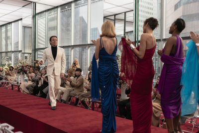 from Halston character walking down runway toward applauding models