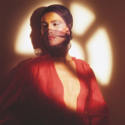 Woman wrapped in red scarf with shadow of window over her face