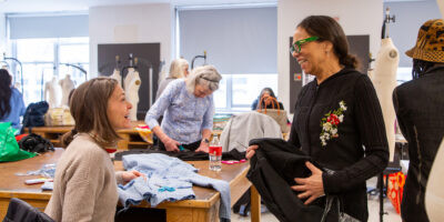 senior learners cut fabric at work tables 
