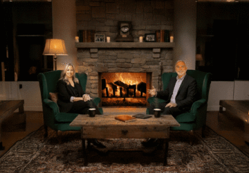 Sarah Clarke and David Uricoli sit in front of a fireplace