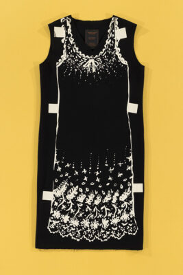 black dress with a dress screenprinted on top of it with tabs designed to make it resemble a paper doll's dress
